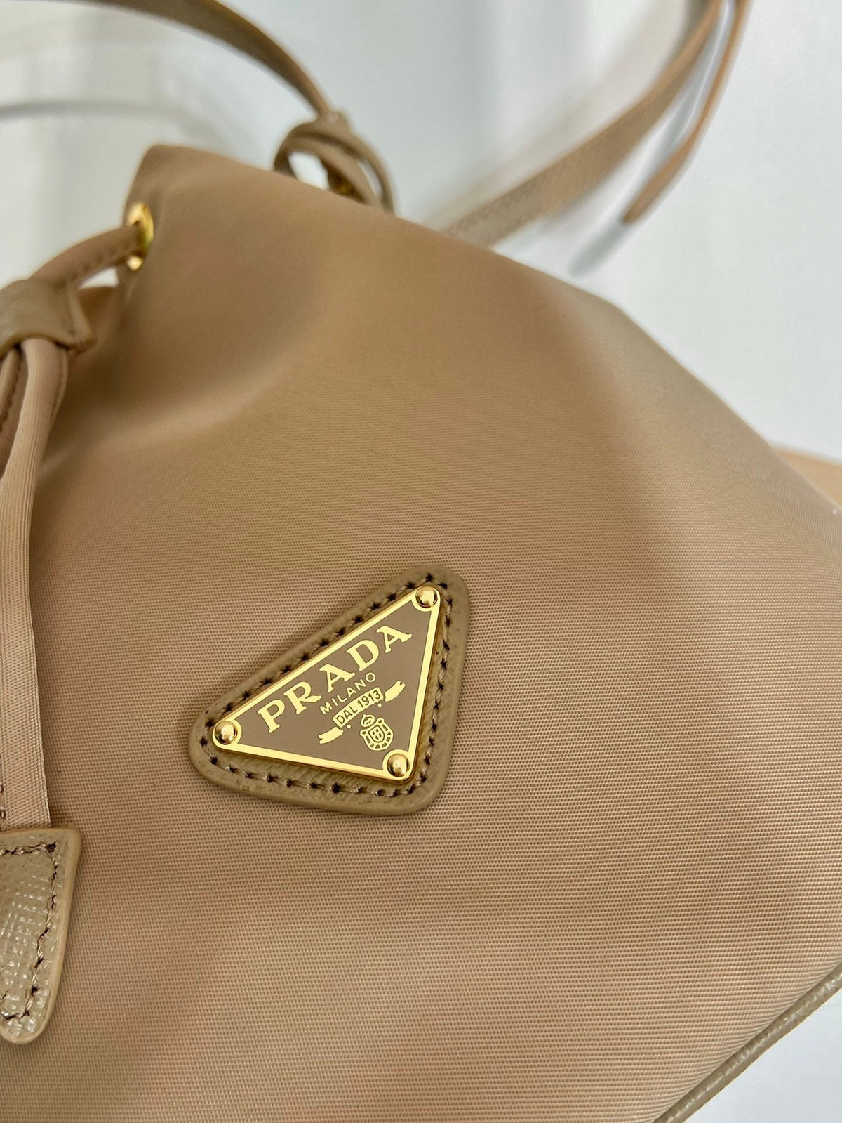 PRADA BUCKET BAG 19 IN BEIGE RE-NYLON AND SAFFIANO LEATHER HANDLE